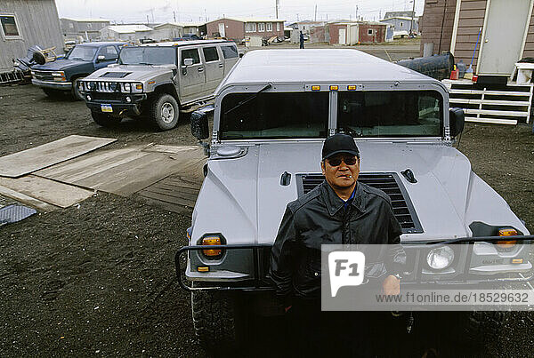 An Inuit man standing in front of his all terrain vehicle; North Slope  Alaska  United States of America
