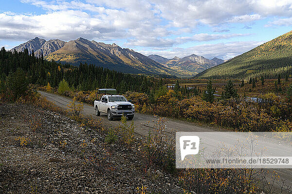 Truck drives along the South Canol Road in the Yukon during a beautiful early fall day; Yukon  Canada