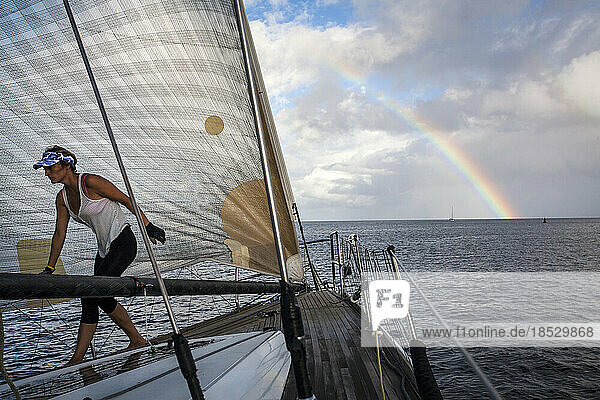 Segeln vor der Insel Grenada in der Karibik mit einem Regenbogen in den Gewitterwolken im Hintergrund. Szene von der Mt. Gay Rum-Yachtregatta 2011  bei der die Insel Grenada umrundet wird; Grenada  Westindien