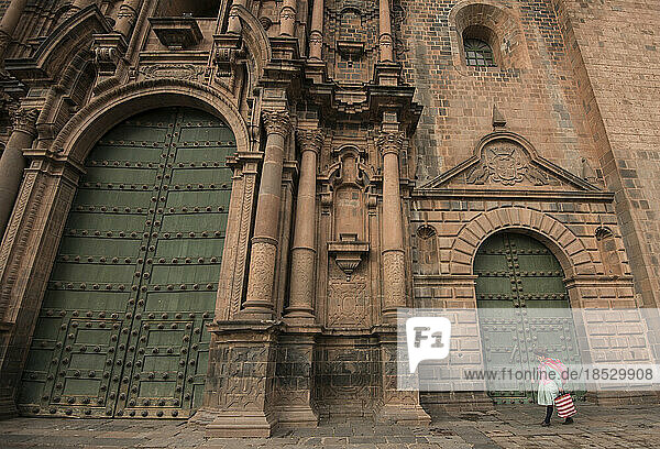 Frau geht an den Türen der Kathedrale von Cuzco vorbei; Cuzco  Peru