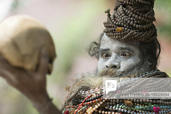 Sadhu bei der Betrachtung eines Schädels; Varanasi  Indien