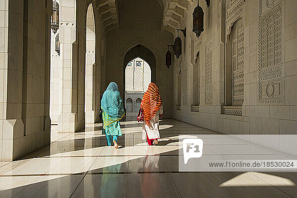 Zwei traditionell gekleidete Frauen gehen durch einen Korridor der Sultan-Qaboos-Großmoschee; Muscat  Oman