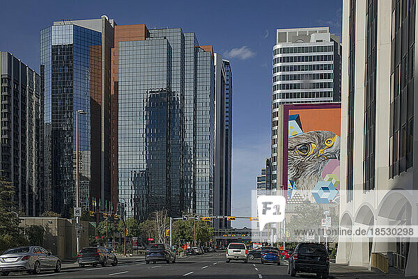 Belebte Straßenszene in der Innenstadt von Calgary  Alberta  mit Verkehr  Wolkenkratzern und einem bunten Wandgemälde; Calgary  Alberta  Kanada