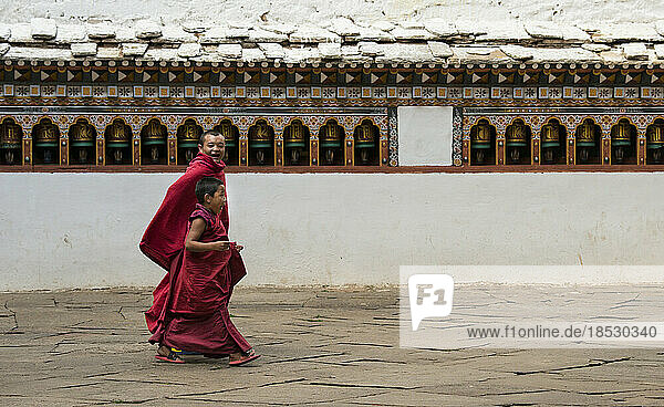 Zwei junge Mönche beim Gang durch ein Kloster; Paro-Tal  Bhutan