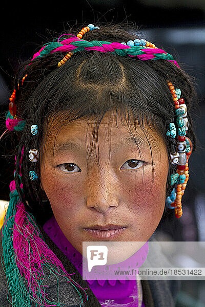 Porträt einer jungen Frau mit Kopfschmuck auf dem Borkhar-Markt; Lhasa  Tibet