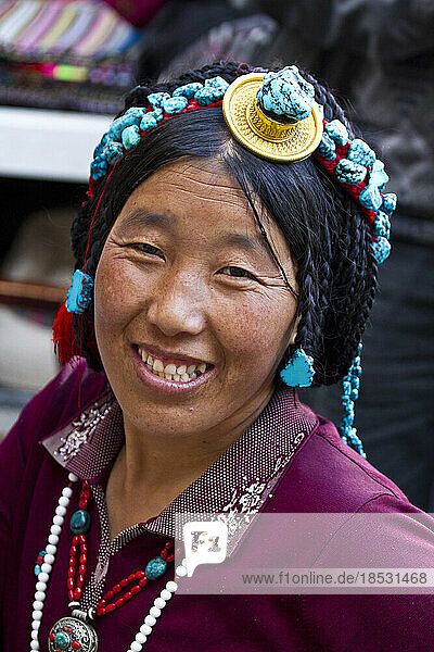 Lächelnde Frau mit Kopfschmuck auf dem Borkhar-Markt; Lhasa  Tibet