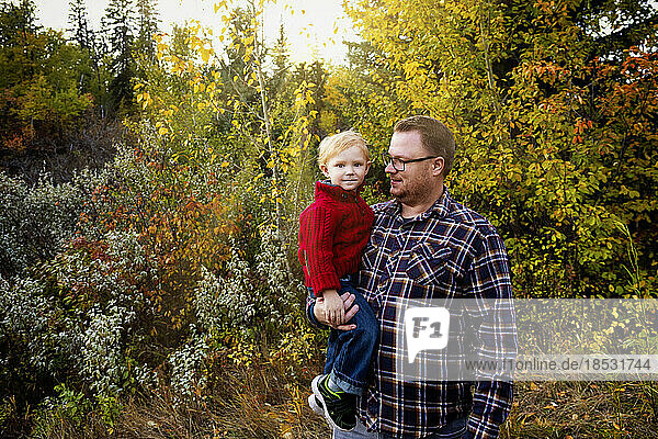 Portrait of a father with his young son outdoors in a park area in autumn; Edmonton  Alberta  Canada