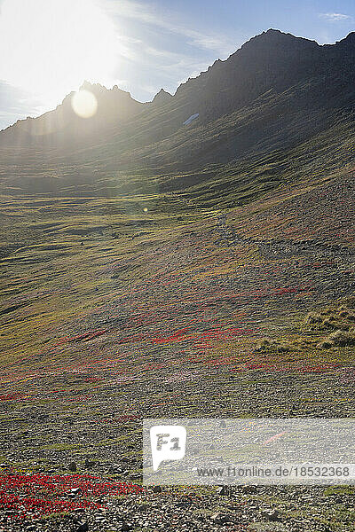 Sonnenstrahlen über der farbenfrohen Herbsttundra entlang des Wanderwegs durch die Chugach Mountains im Chugach State Park; Anchorage  Alaska  Vereinigte Staaten von Amerika