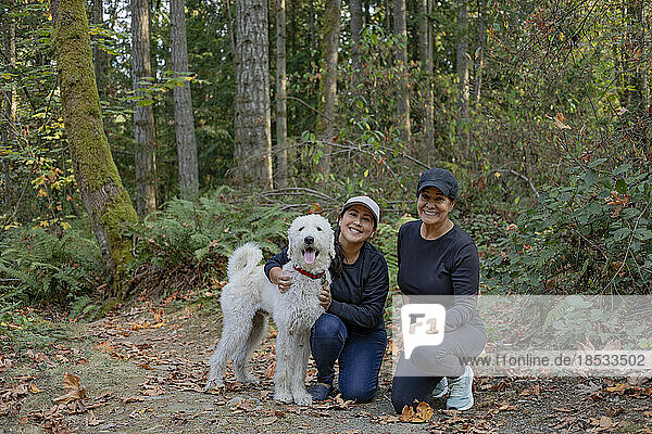 Porträt von zwei Frauen mit einem Hund in einem Waldgebiet; Vancouver Island  British Columbia  Kanada