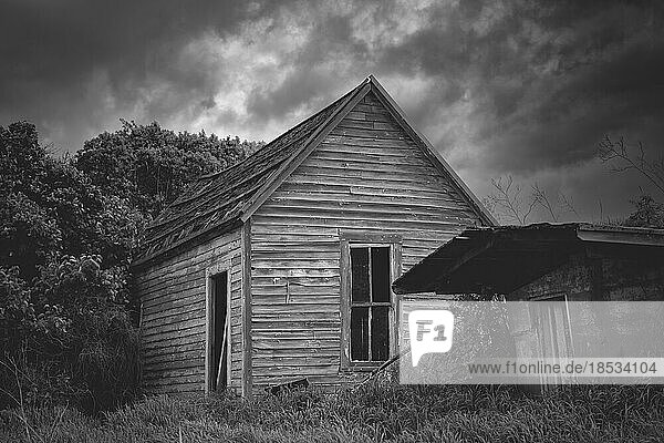 Schwarz-Weiß-Bild eines gespenstischen alten verlassenen Hauses unter bedrohlichen Wetterwolken im östlichen Washington  USA; Colfax  Washington  Vereinigte Staaten von Amerika
