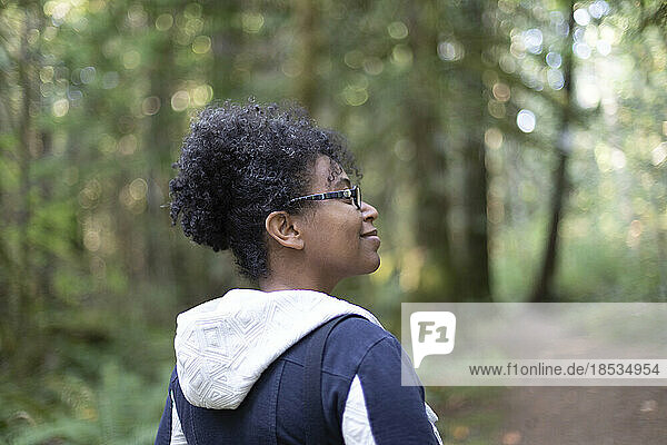 Frau im Freien  die die Natur genießt  während sie auf einem bewaldeten Weg im Stamp River Provincial Park lächelt; Port Alberni  British Columbia  Kanada