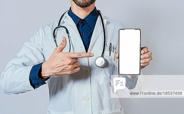 Doctor showing and pointing to blank cell phone screen. Doctor recommending on cell phone screen isolated