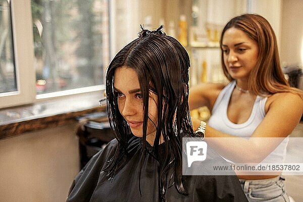 Professionelle Friseurin schneidet die Haare einer Frau bei der Arbeit im Schönheitssalon