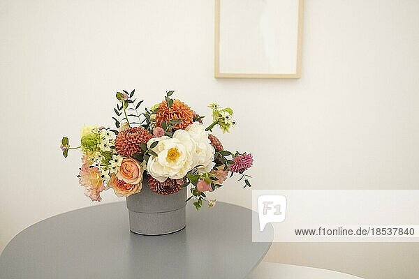 Glass vase with bouquet of beautiful flowers on table in cozy room. Space for text
