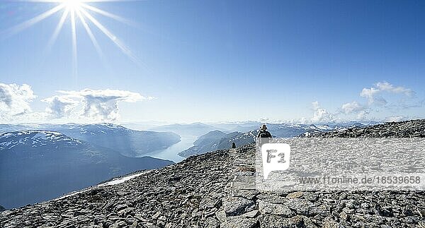 Wanderer beim Aufstieg zum Gipfel des Skåla  Ausblick auf Berge und Fjord Faleidfjorden  Sonnenstern  Loen  Norwegen  Europa