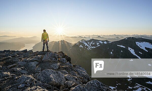 Hiker looking into the sunset  sun star  view of mountains and fjord Faleidfjorden  top of Skåla  Loen  Norway  Europe