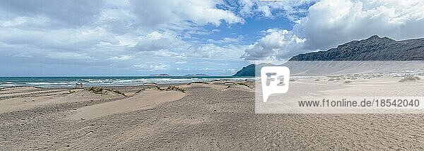 Panoramaaufnahme des Strandes Playa de Famara und der Bergkette auf Lanzarote  Kanarische Inseln  vor dem Hintergrund von Meer und Himmel