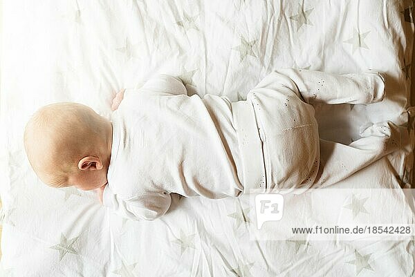Blick von oben auf ein einen Monat altes Baby auf einer Decke  das versucht  seinen Kopf zu heben