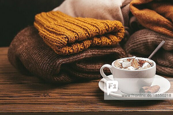 Cozy Winter Zusammensetzung  Tasse mit heißer Schokolade oder Kakao mit Marshmallow und Stapel von warmen gestrickte Kleidung auf Holz rustikalen Hintergrund. Gemütliche und weiche Winter zu Hause  freier Raum für Text
