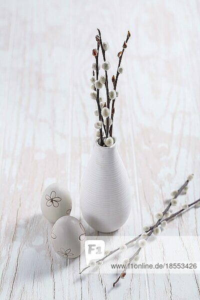 Muschelweidenzweige in Vase mit Osterei auf hölzernem Küchentisch. Ostern Tischdekoration