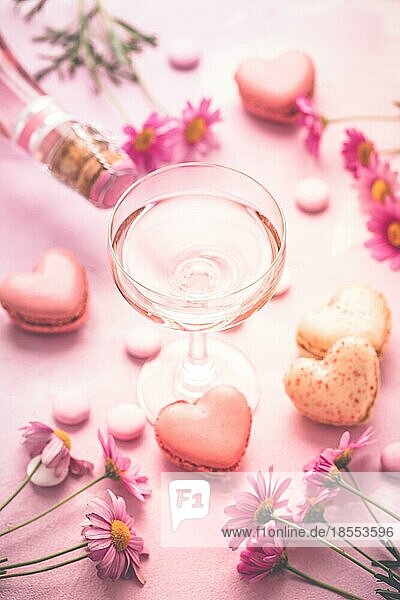 Happy Mothers Day süße Macarons in Herzform und ein Glas Rosensekt mit Blumen in Rosatönen