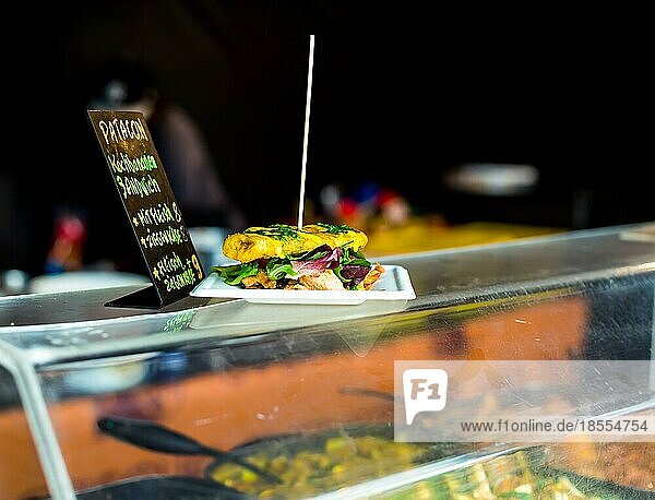 Patacon Sandwich traditionelles Sandwich aus Kochbananen (Kochbananen) mit Hühnerfleisch und Kopfsalat. Frisch zubereitet im Food Truck. Afrikanisches Essen