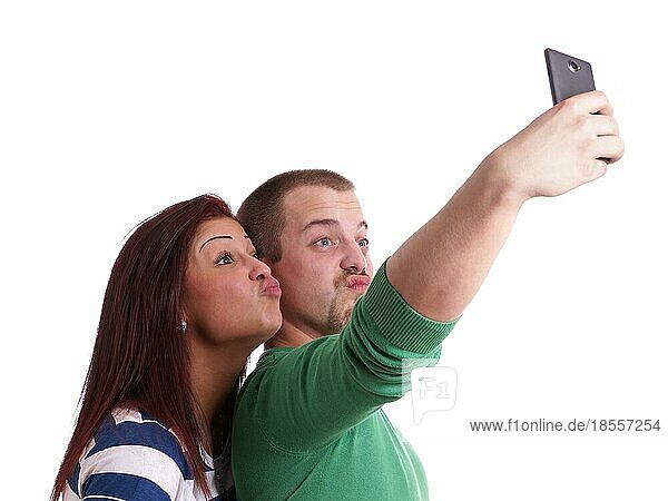 Junge Leute machen ein dummes Entengesicht  während sie ein Selbstporträt mit dem Smartphone aufnehmen
