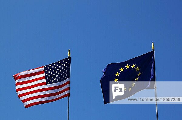 Die Flaggen der USA und der EU wehen nebeneinander im Wind