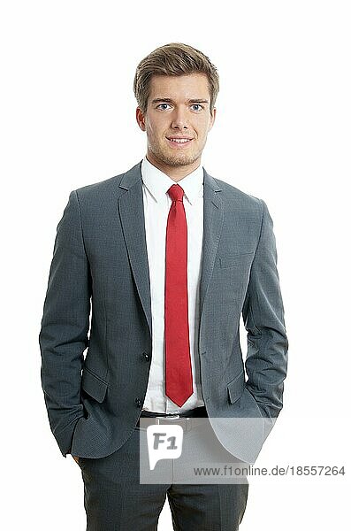 Junger Mann in Anzug und Krawatte mit Händen in den Taschen
