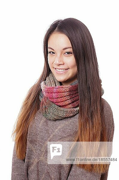 Lächelnde junge asiatische Frau mit Wollpullover und Schal