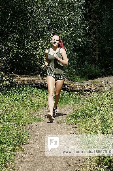 female jogger running on a forest path