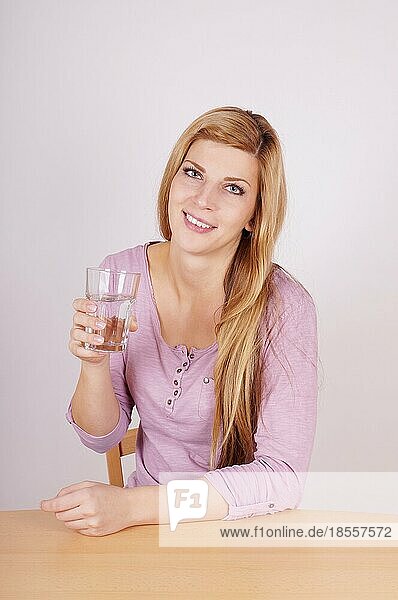Junge Frau hält ein Glas Wasser