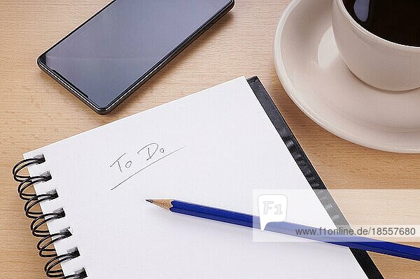 To-Do-Liste mit Notizblock  Bleistift  Handy und Tasse Kaffee auf dem Schreibtisch