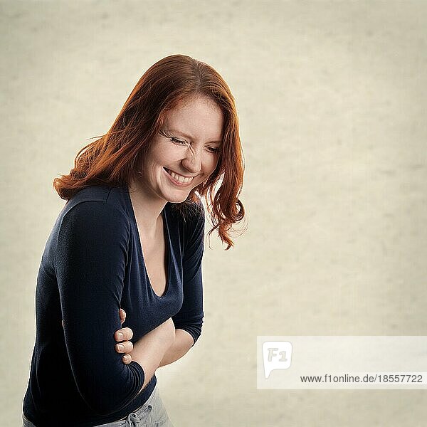 Junge Frau lachend mit texturiertem Hintergrund mit Kopierraum