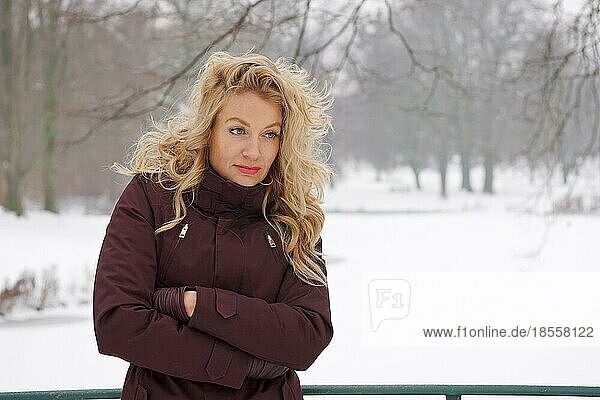 sad woman freezing in snow covered winter landscape