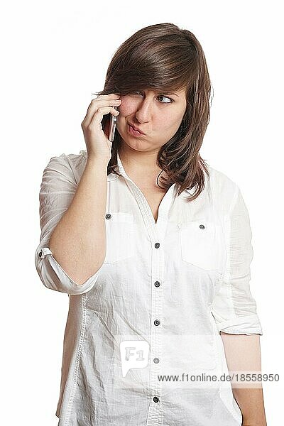 Junge Frau verzieht das Gesicht während eines Mobiltelefonats