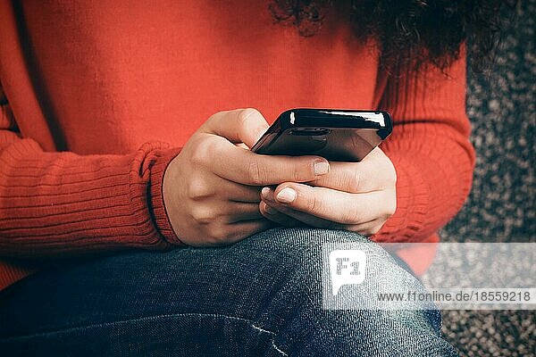 close-up of female hands using smart phone typing text message. with faded color retro filter