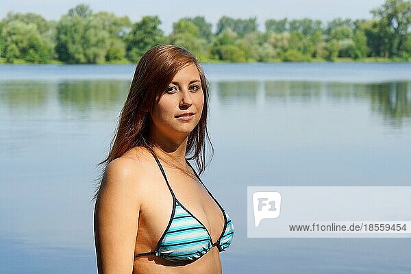 young woman wearing bikini at idyllic bathing lake