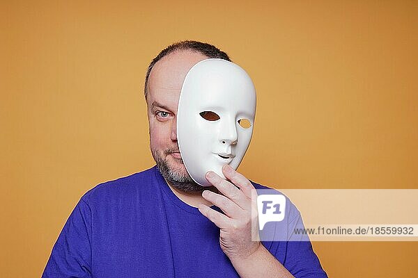 Erwachsener Mann nimmt Maske ab und enthüllt Gesicht und Identität