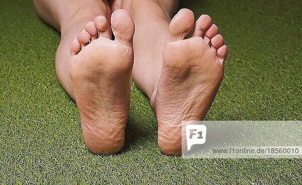 Fußsohlen einer nicht erkennbaren barfuß gehenden weiblichen Person