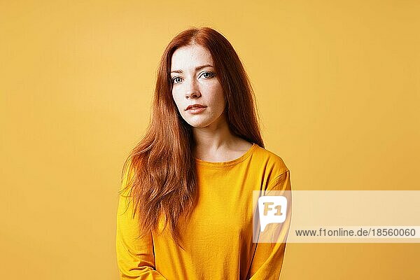 Hübsche junge Dame mit neutralem Gesichtsausdruck - Frau mit roten Haaren und gelber Farbgebung