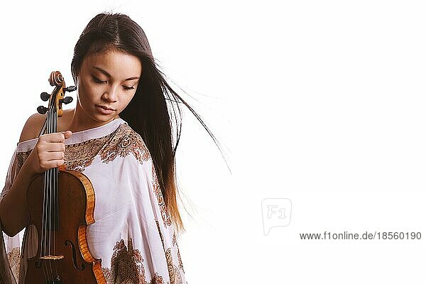 Eine junge asiatische Frau mit geschlossenen Augen  die eine Geige hält