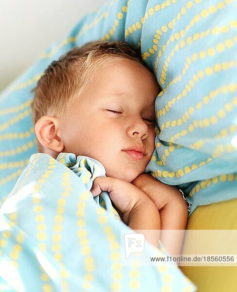 Kleiner Junge schläft friedlich im Bett