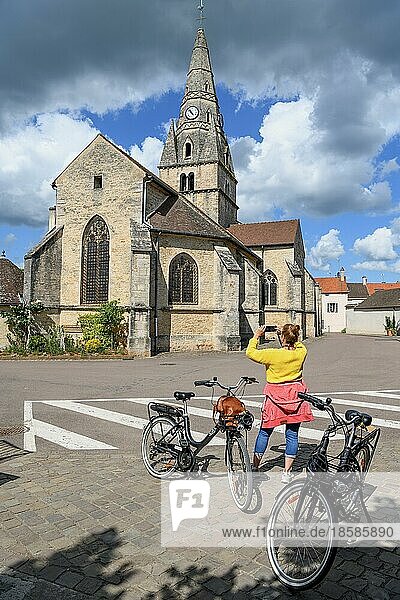 Radfahrerin vor der Kirche Église Saint-Cassien macht Fotos  Savigny-lès-Beaune  Département Côte-d?Or  Burgund  Frankreich  Europa