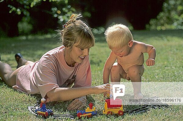 Frau und Kleinkind spielen im Garten