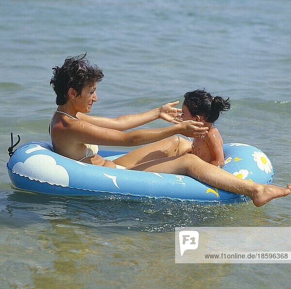 Mutter mit Tochter im Schlauchboot im Wasser