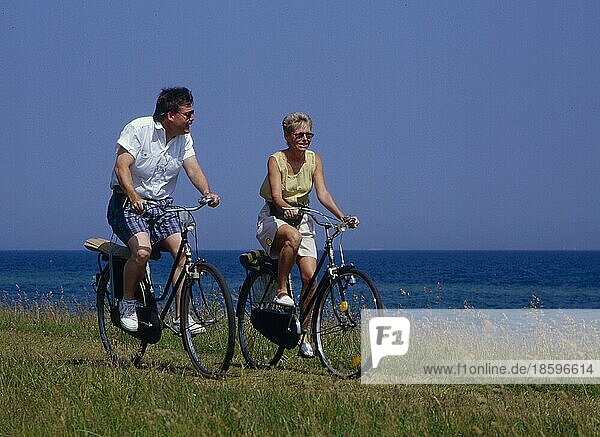 Elderly couple  cycling tour by the sea  North Sea