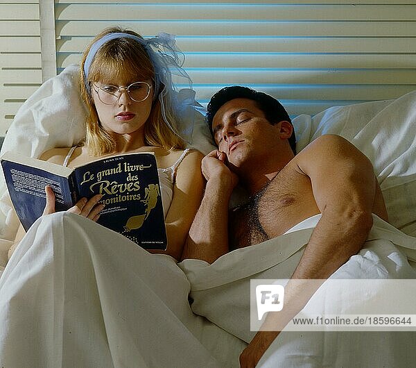 Mann und Frau im Bett Frau liest Zeitung  Mann schläft schon