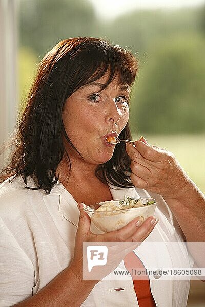 Frau mit Schüssel Obstsalat mit Joghurt  Schüssel  Löffel