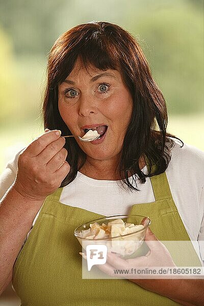 Frau mit Schüssel Obstsalat mit Joghurt  Schüssel  Löffel  probieren  probiert